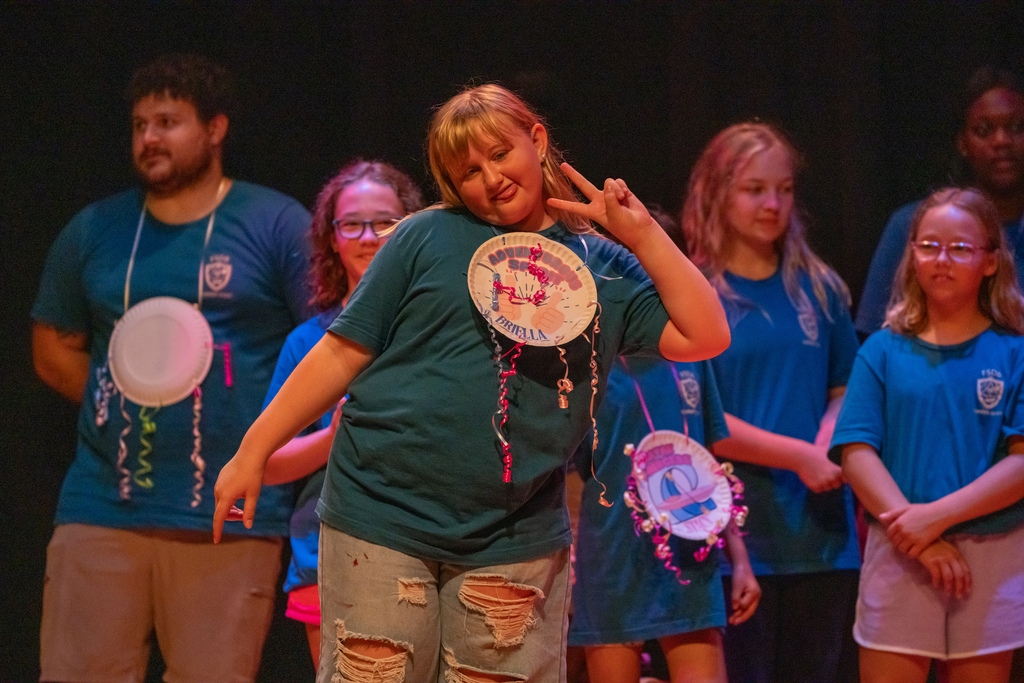 A camper smiles on stage with her award.