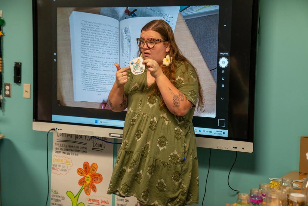 The teacher is reading the story to the class. 