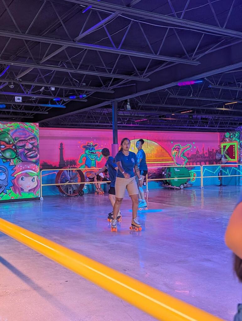 Campers and staff members skate together on the skating rink. 