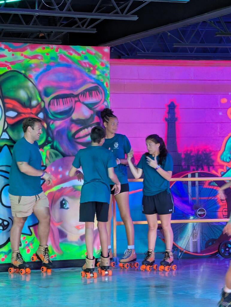 A group of campers talking with a staff member on the skating rink. 