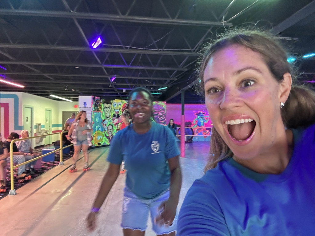 A staff member takes a selfie with a camper in the skating rink. 