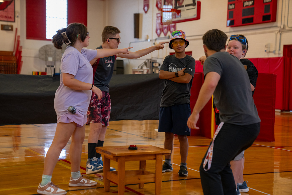The campers work on the skit together inside the gym. 