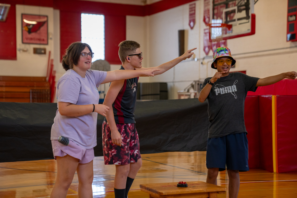 Three campers are practicing the skit inside the gym.