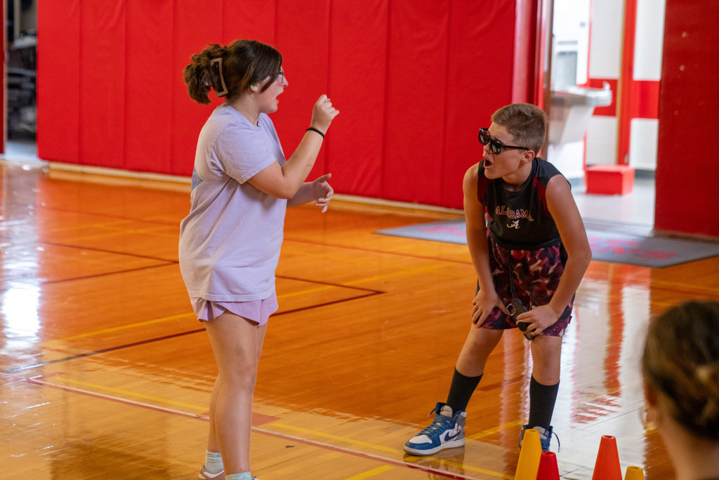 Two campers work on the skit inside the gym. 