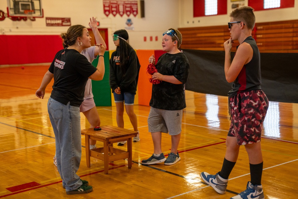 The staff member and the campers discuss their Idas inside the gym. 