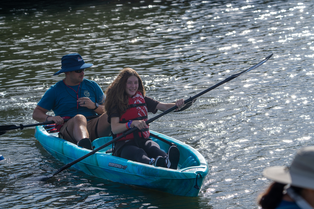 A camper and staff member kayak out on the waters. 