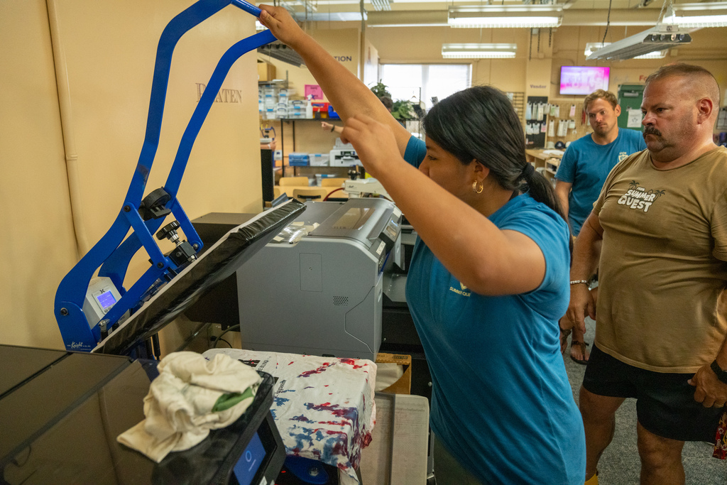 A camper is learning how to print her tie dye shirt with a FSDB logo inside DB Designs. 