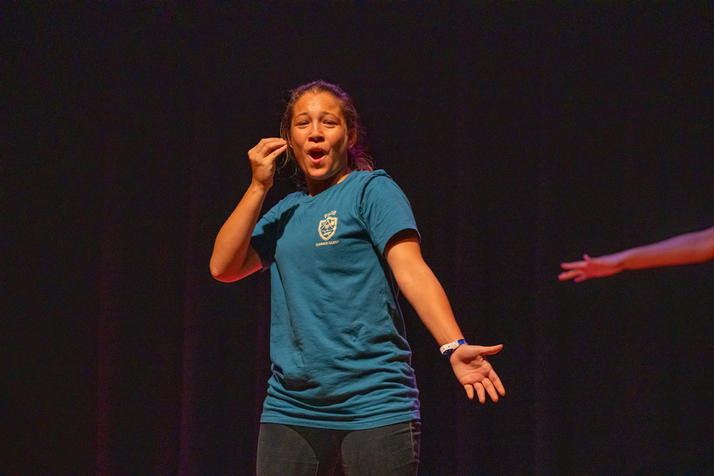 A camper signs on stage in the music building.
