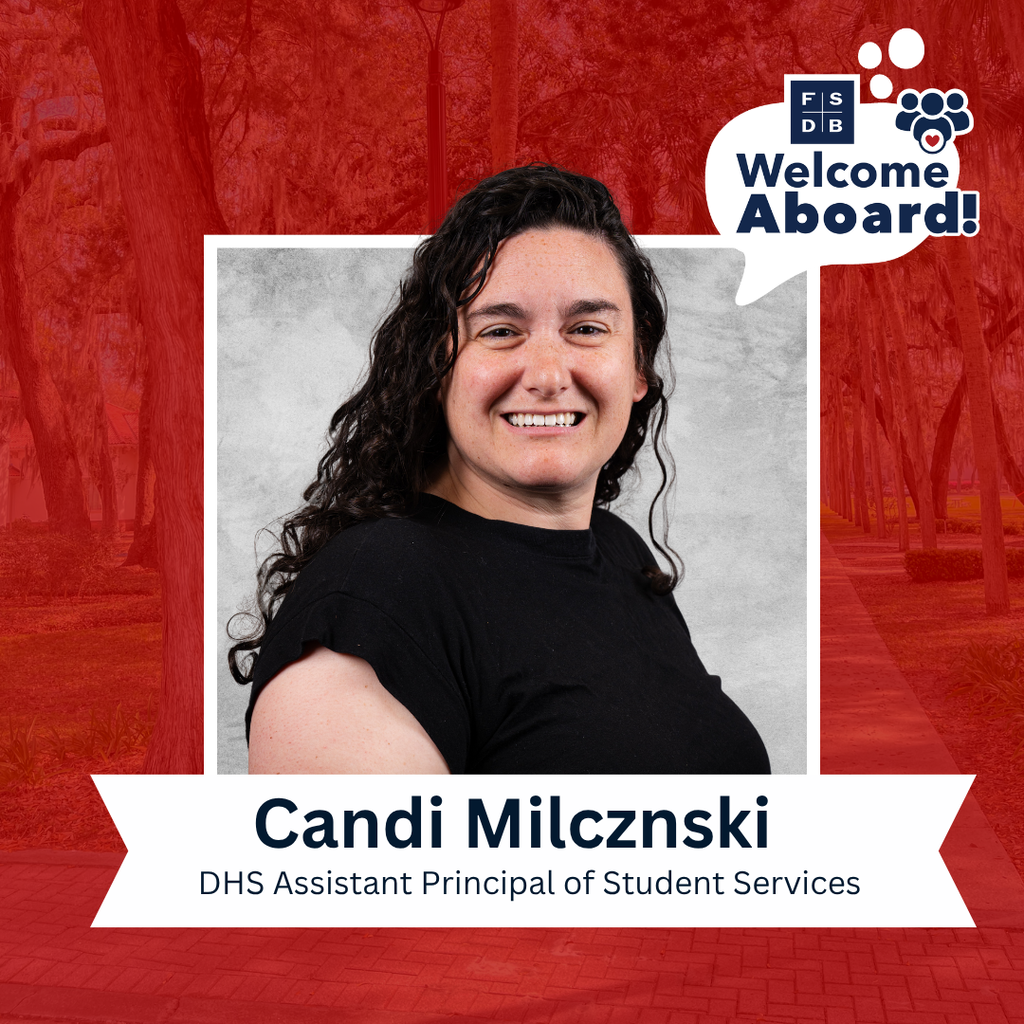 Candi is wearing a black shirt and smiling for her photo with a silver backdrop and red background. Below her photo is a white graphic that says "Candi Milcznski, DHS Assistant Principal of Student Services" 