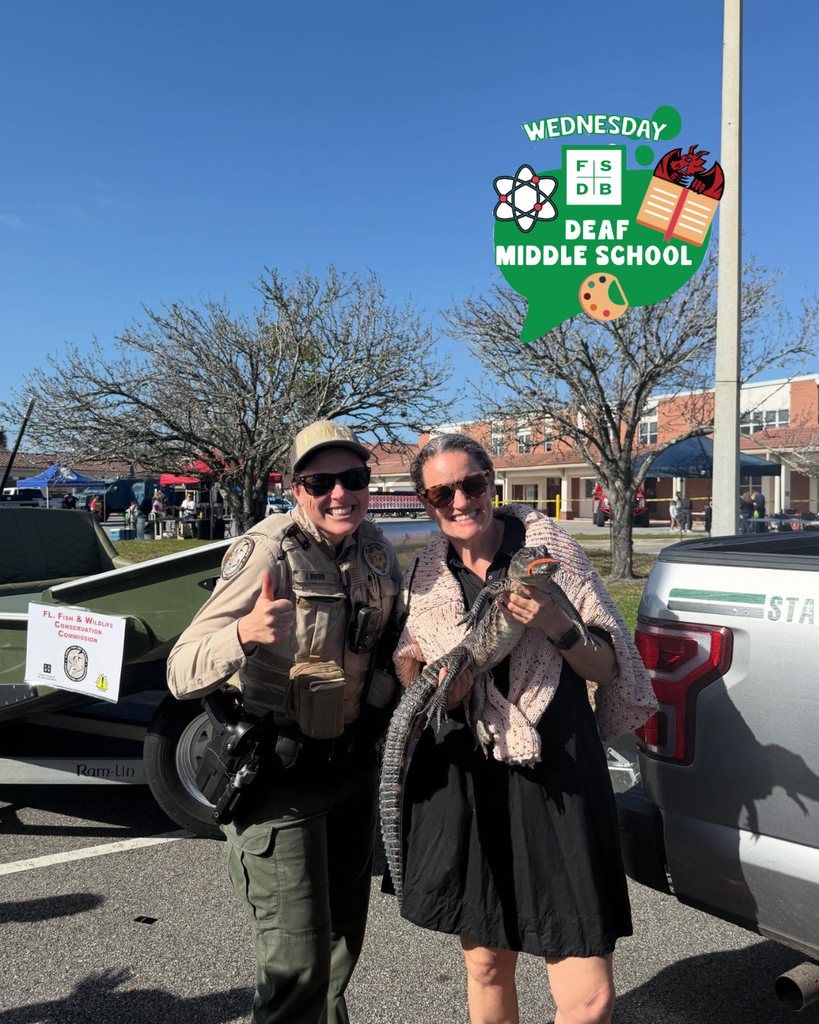 Deaf Middle School Assistant Principal holds a baby gator and smiles with a Wildlife officer outside on campus.
