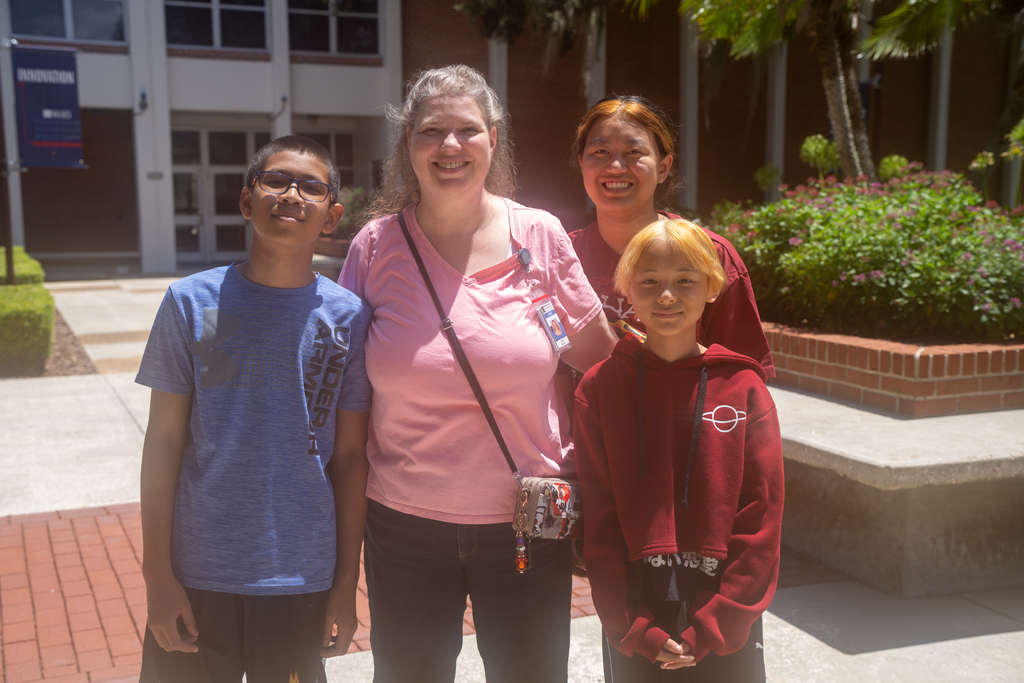 Three FSDB students smile with their Mom outside.