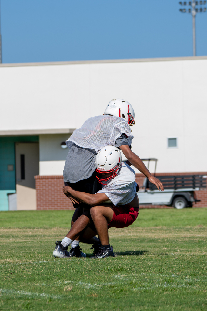 Football players tackle each other out on the field.