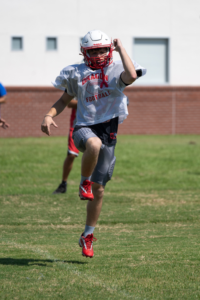 A football player is warming up with exercises on the field. 