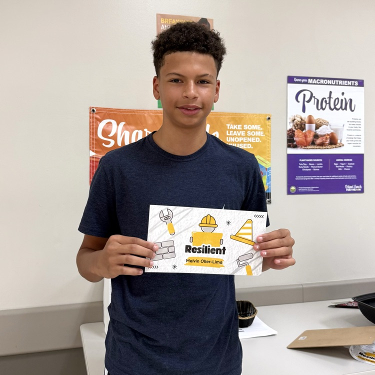 DMS student, Melvin, holding his award and smiling.