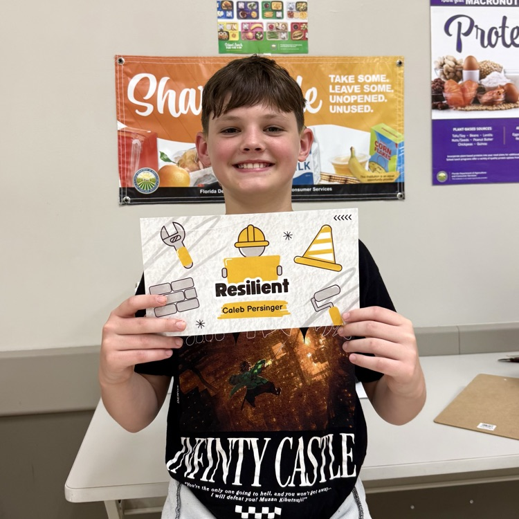 DMS student, Caleb, holding his award and smiling.