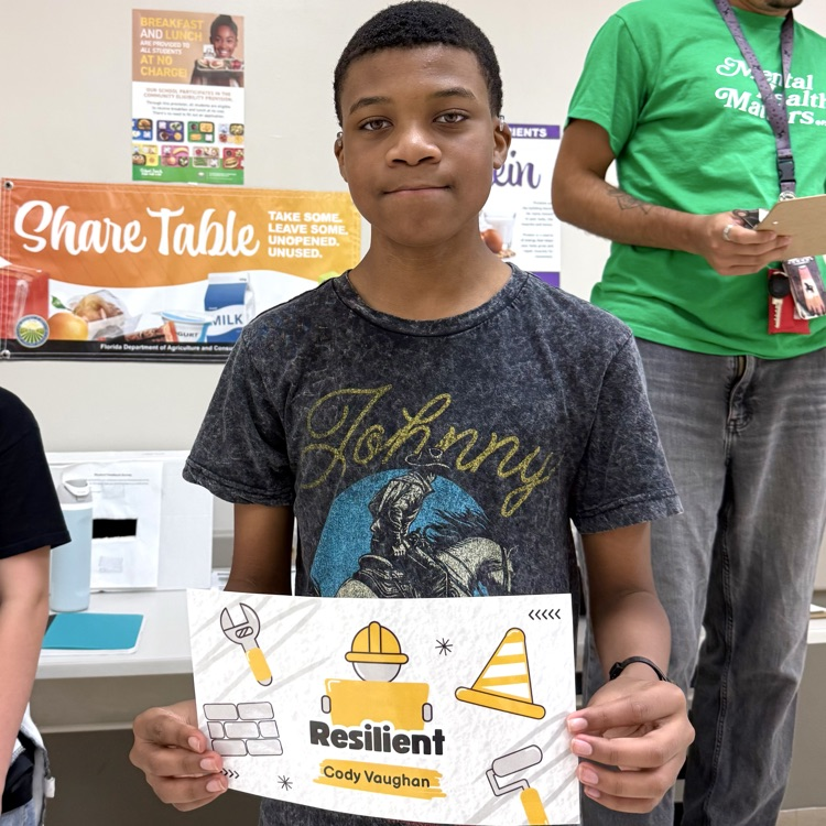 DMS student, Cody, holding his award and smiling.