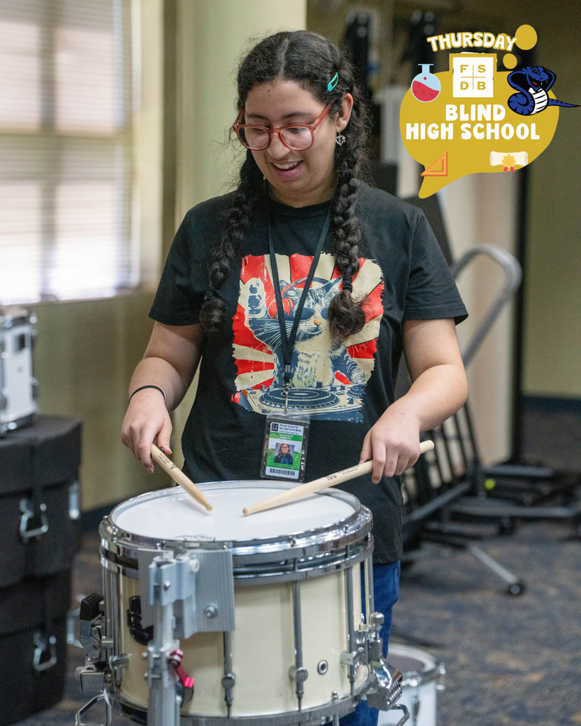 Student playing the drums inside the music building.
