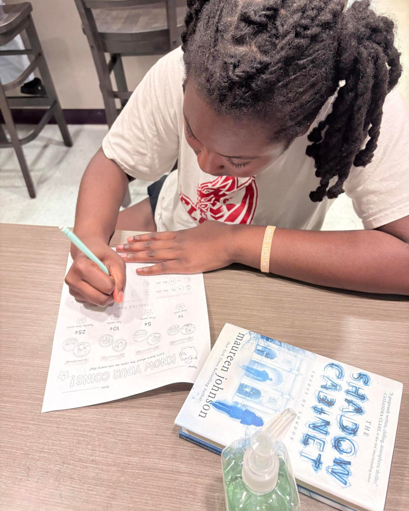 A student working on a counting coins paper in James Hall.