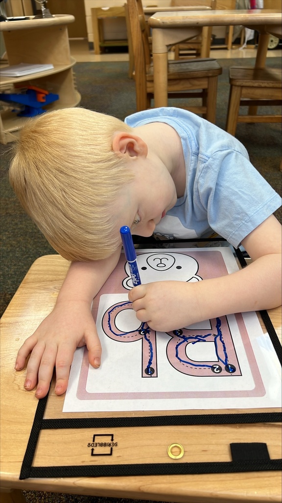 A ELC student is practicing writing the letter "B" inside the classroom.