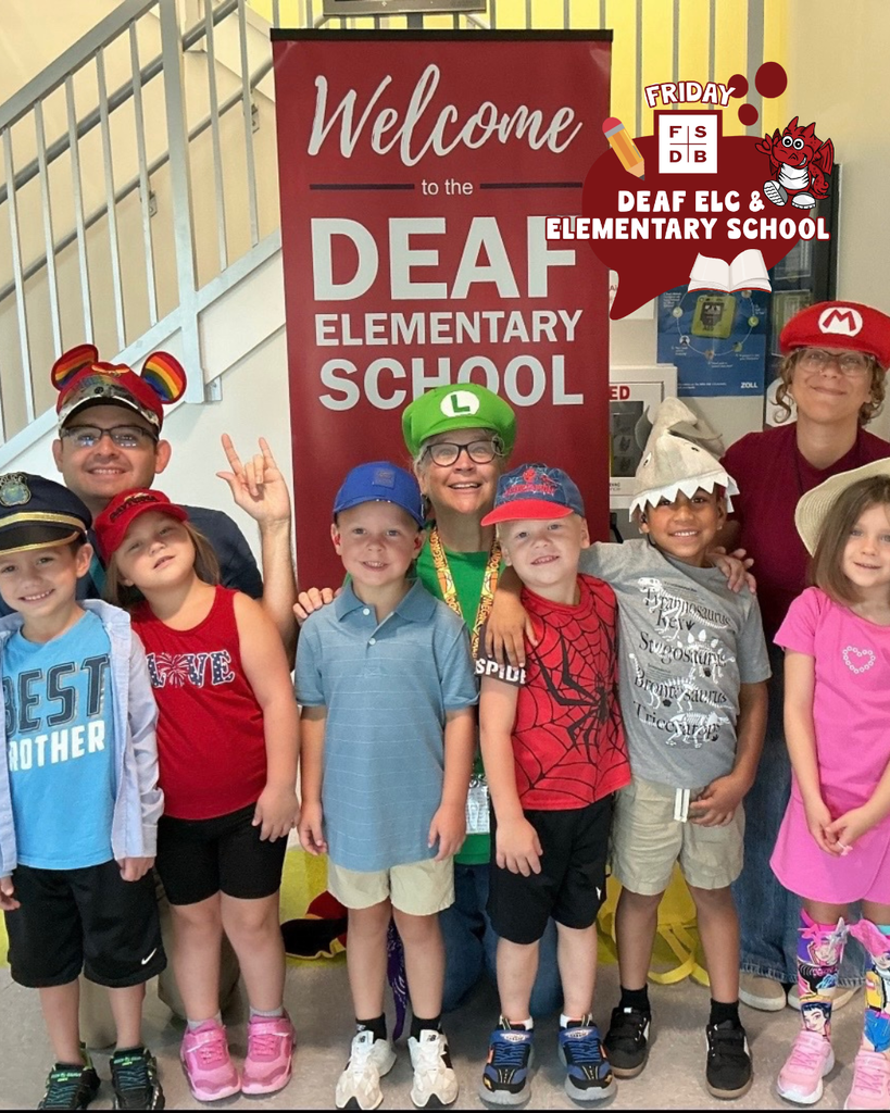 Group of students smile with their teachers wearing hats.