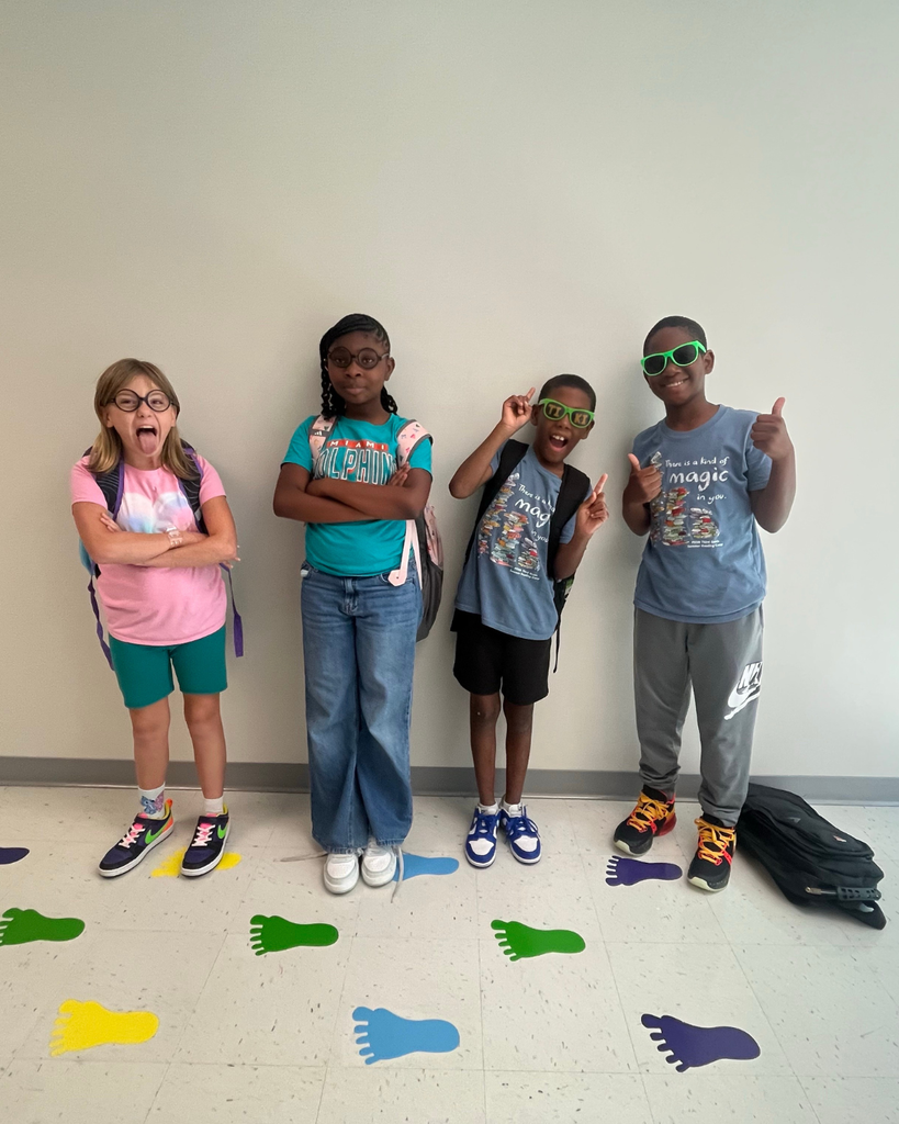 Group of students smile for a photo with glasses.