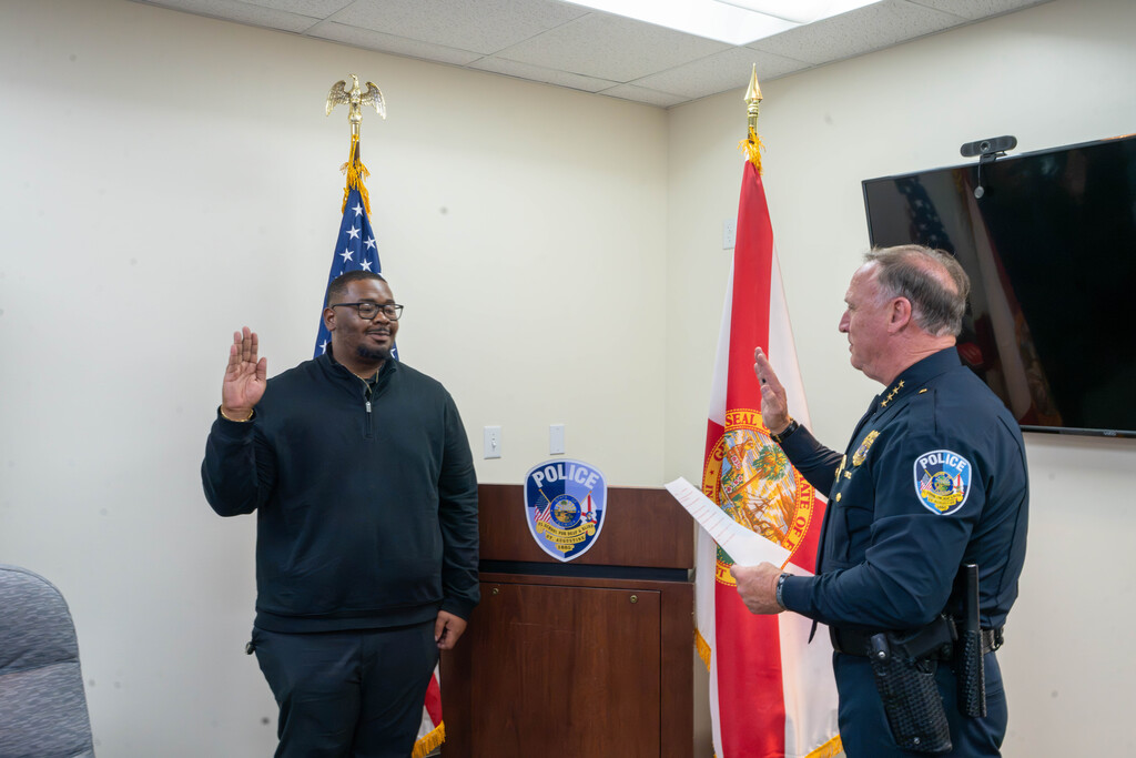 Ne'Darrius holds his hand up with the chief inside the building.