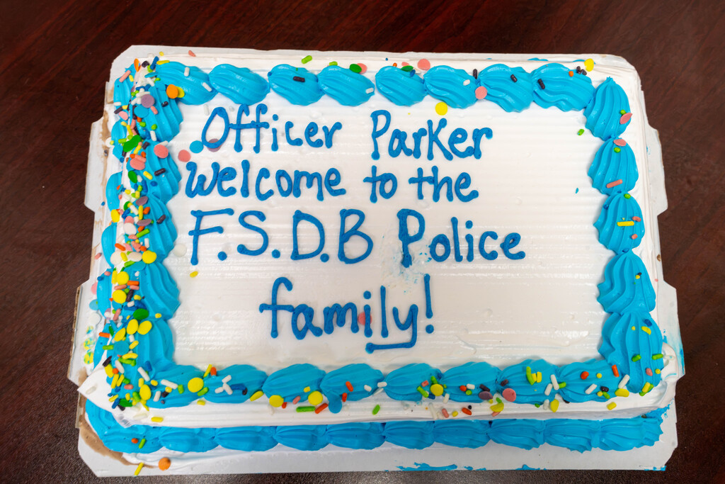 Close up of a cake that says "Office Parker, Welcome to the FSDB Police Family!"