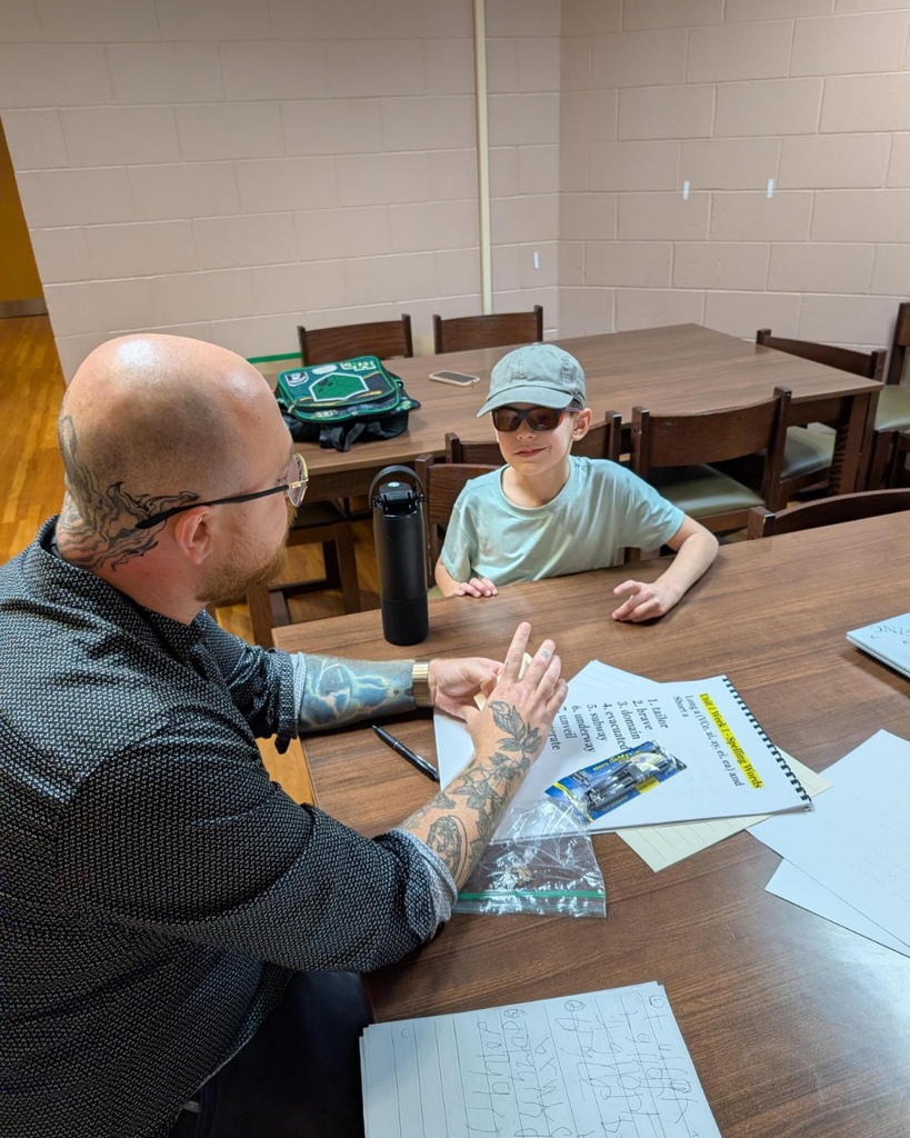 A staff member helps a student with his homework. 