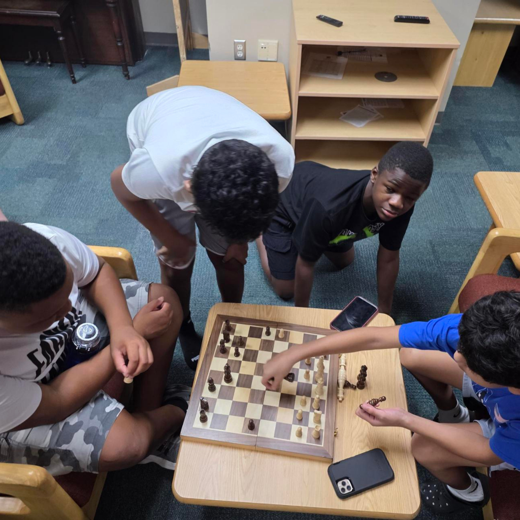 A group of students play chess inside the dorm. 