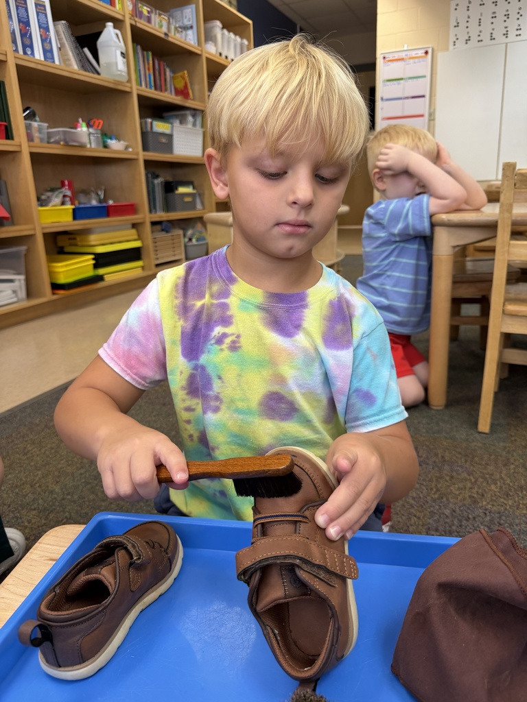 A ELC student is shining shoes inside the classroom.