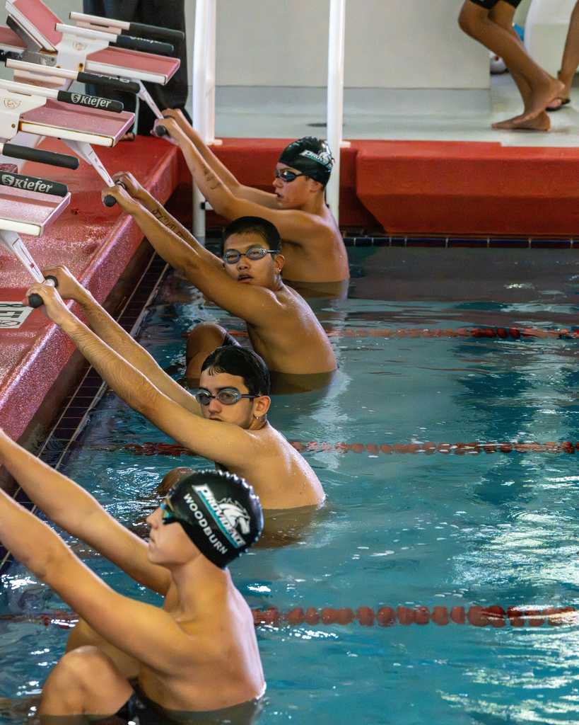 Group of FSDB and Providence swimmers at the starting line inside the pool. 