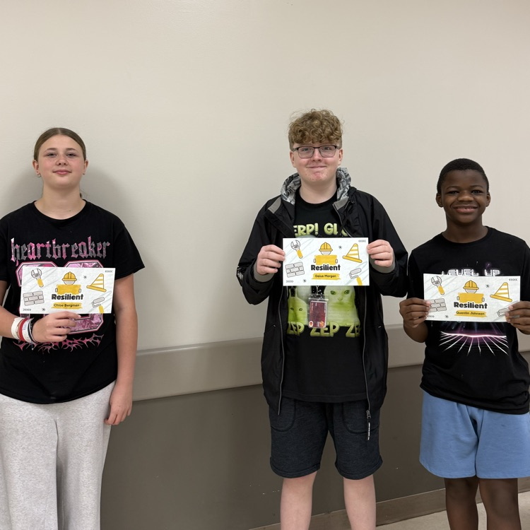 Three students stand in a line holding their Resiliency Awards.