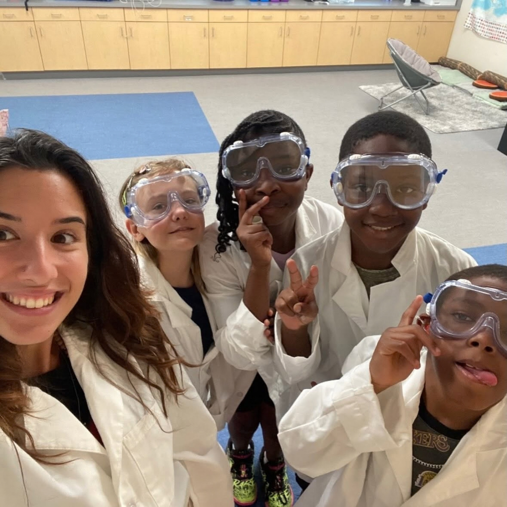 Selfie of the teacher with four students inside the classroom.
