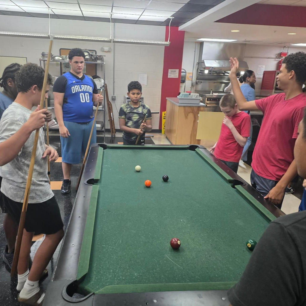 Photo of students playing pool inside the DL. 