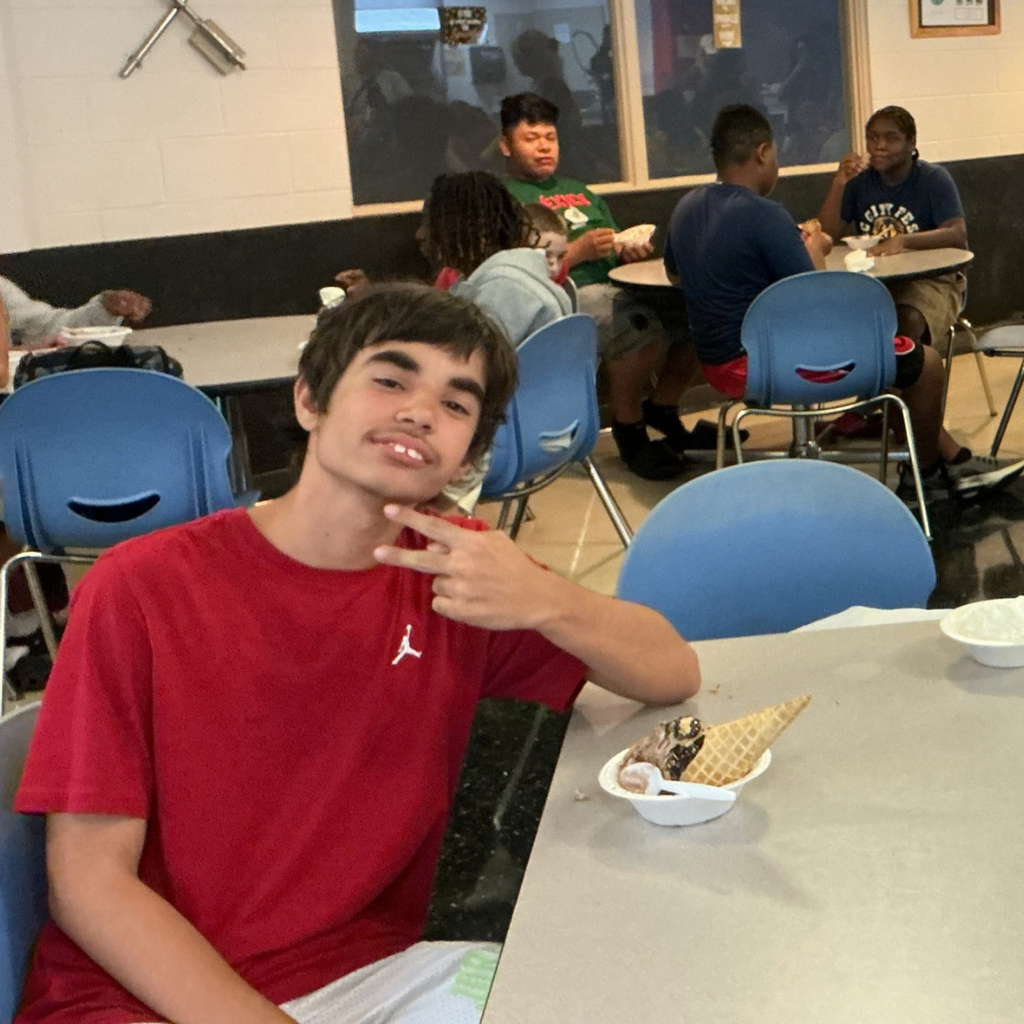 A student pose and smile with his ice cream sundae inside the DL. 