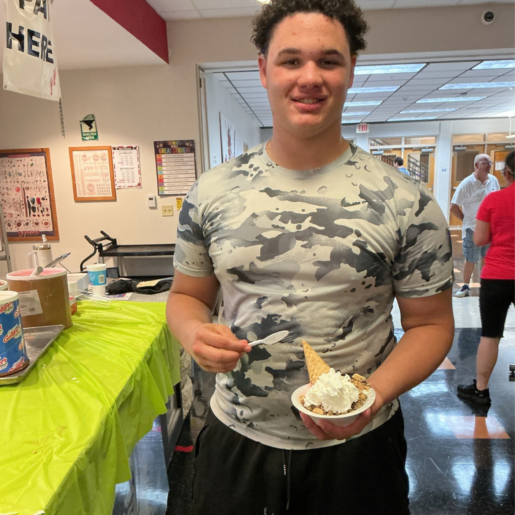 A student smiles with his ice cream sundae inside the DL. 