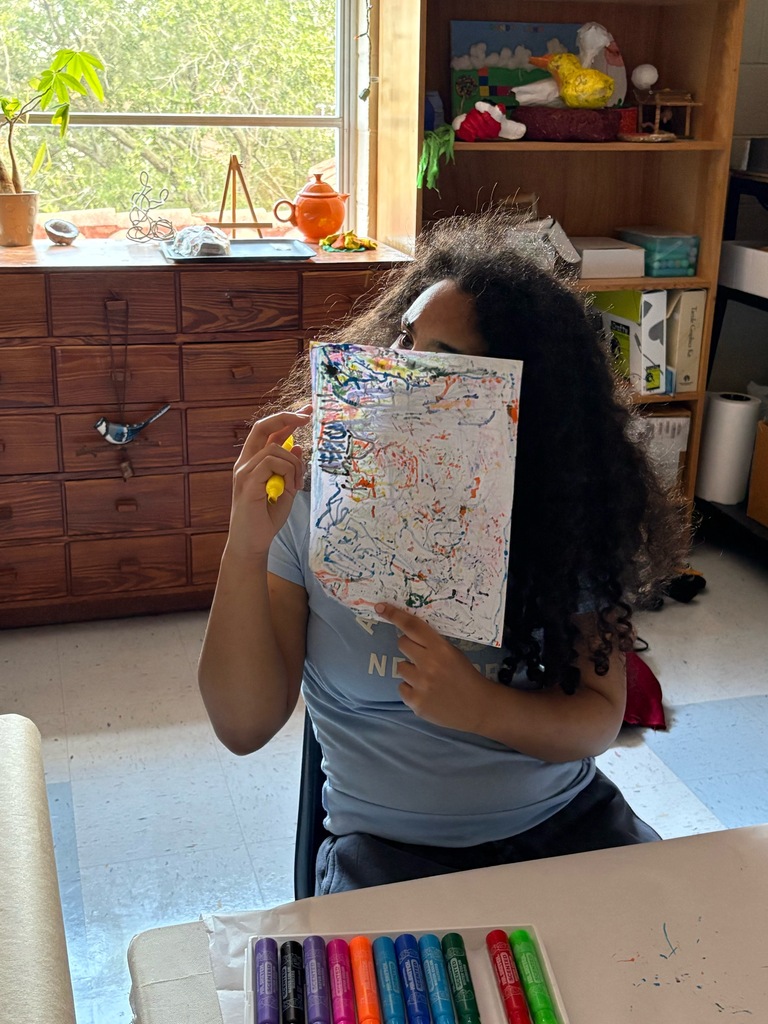 Vivienne examines a paper full of colorful lines and shapes she created with scented markers.