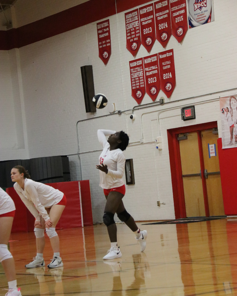 Varsity Volleyball player practices on the court of Settles Gym. 