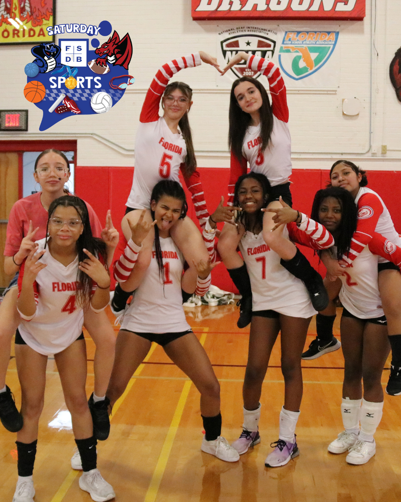 Group of JV volleyball players smile for a photo inside Settles Gym. 