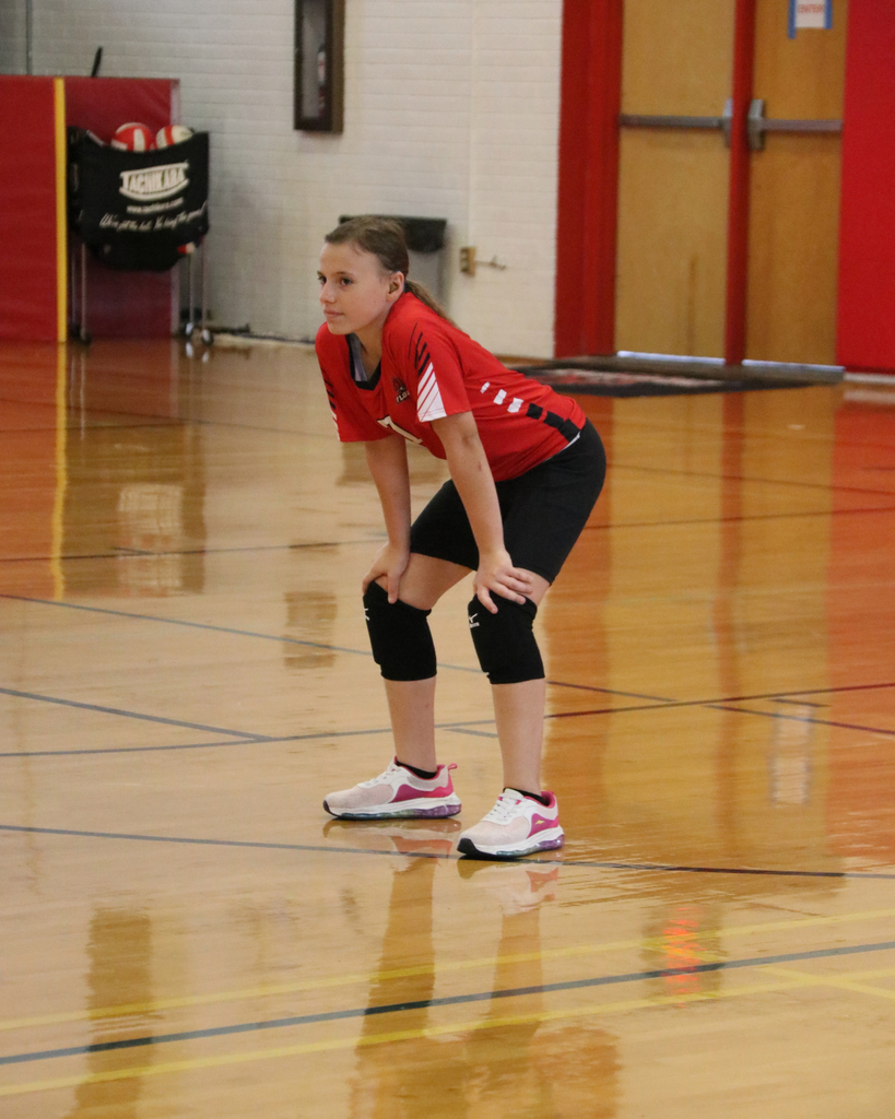 A Middle Schooler Volleyball player bends down and gets ready for a play inside Settles Gym. 