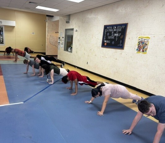 Students doing planks in the Copeland lobby.