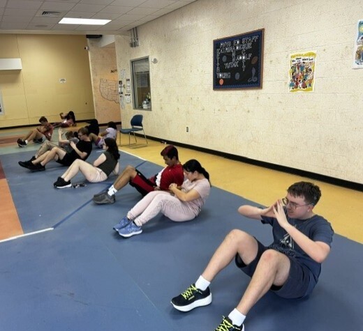 Students doing sit ups in Copeland lobby.