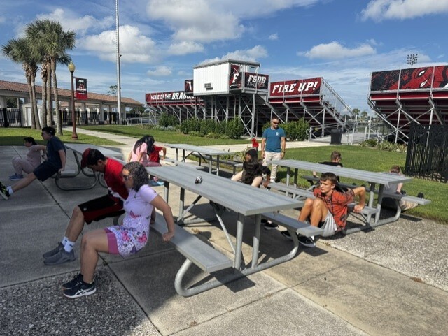 Students doing dips on picnic tables outside of Copeland Gym.