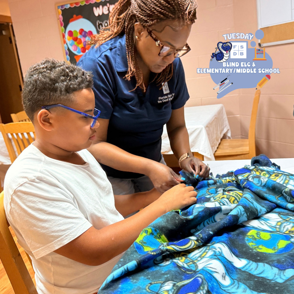 Ms. Laronda helps student sew a blanket inside Cary White.