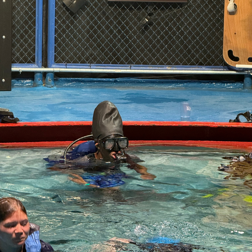 A student dressed up for scuba diving in the water.