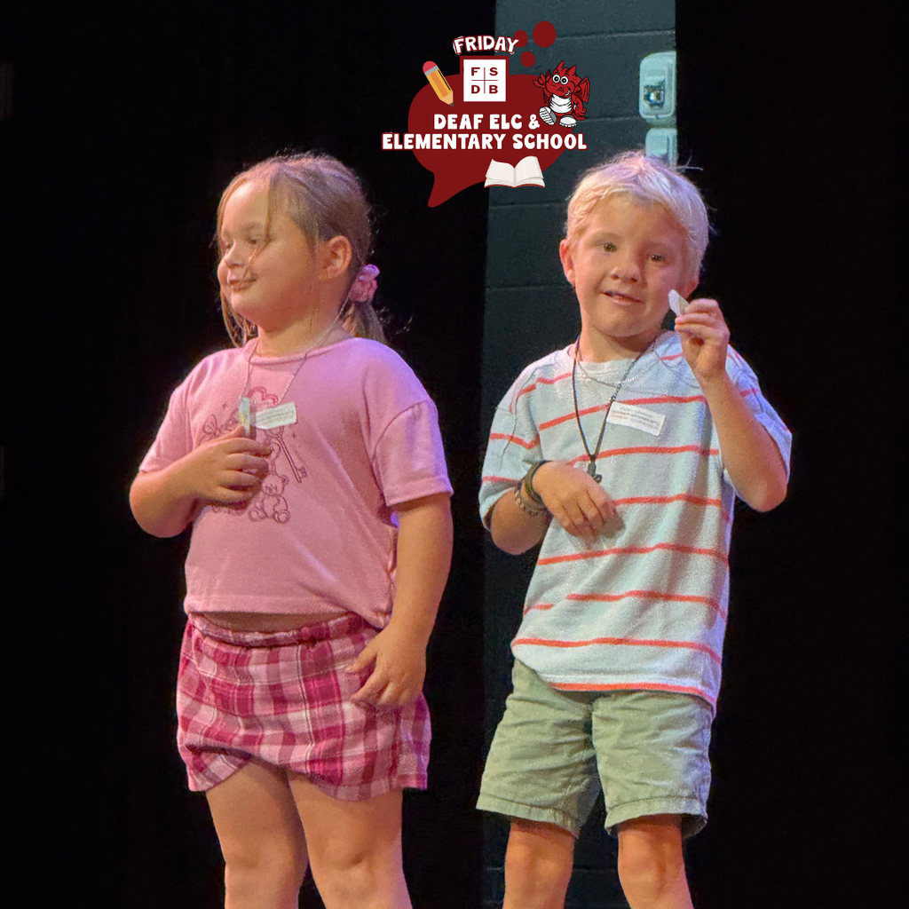 Two students smile on stage in Kirk.