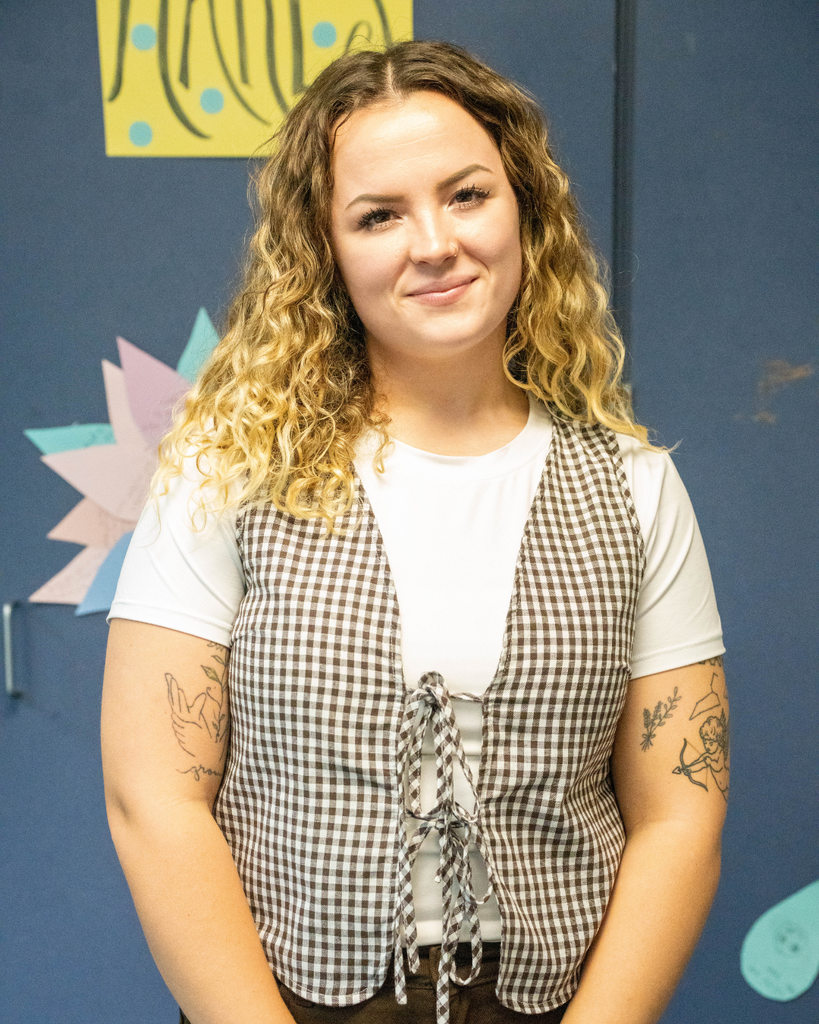 a Deaf Middle School rookie finalist (Kelsey Walsh) stands in front of a colorful school display wall.