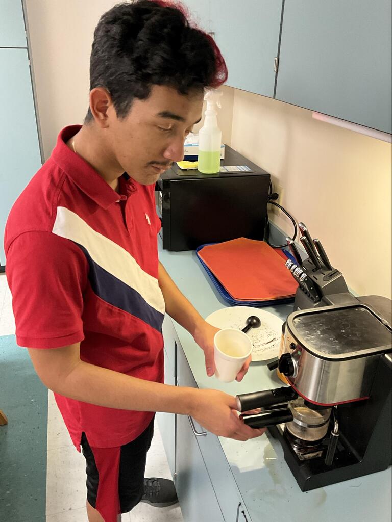 Student learns how to use the espresso machine.