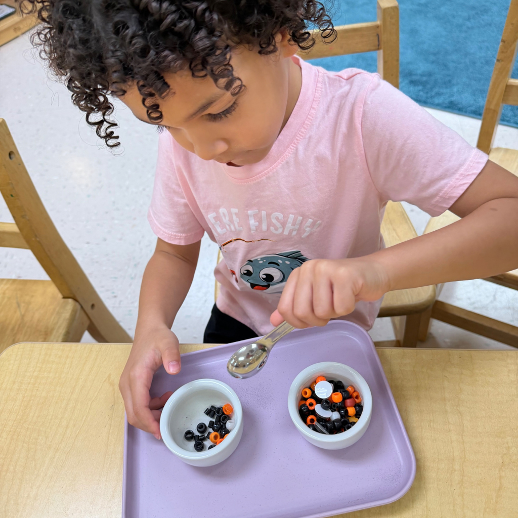 ELC students scoop halloween color beads to a bowl. 