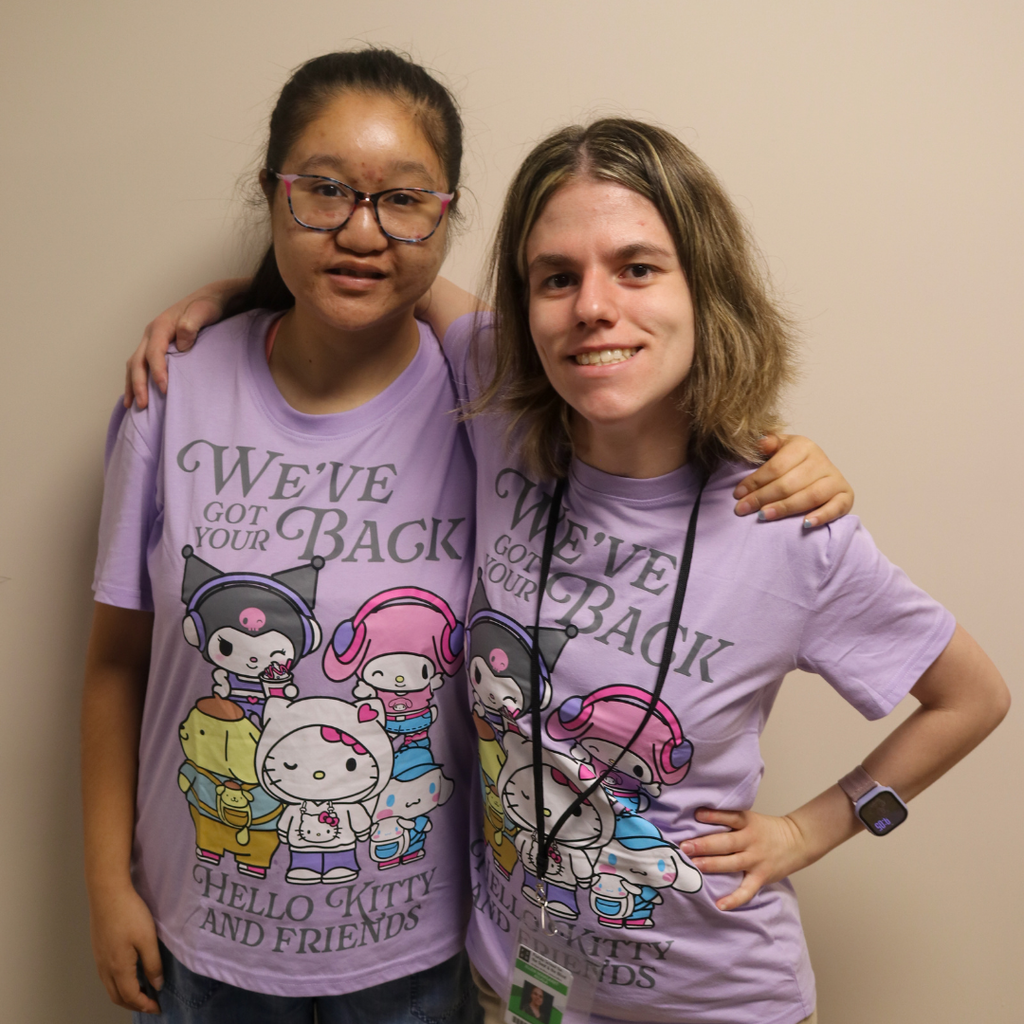 Two students wear matching purple "Hello Kitty" shirts. 